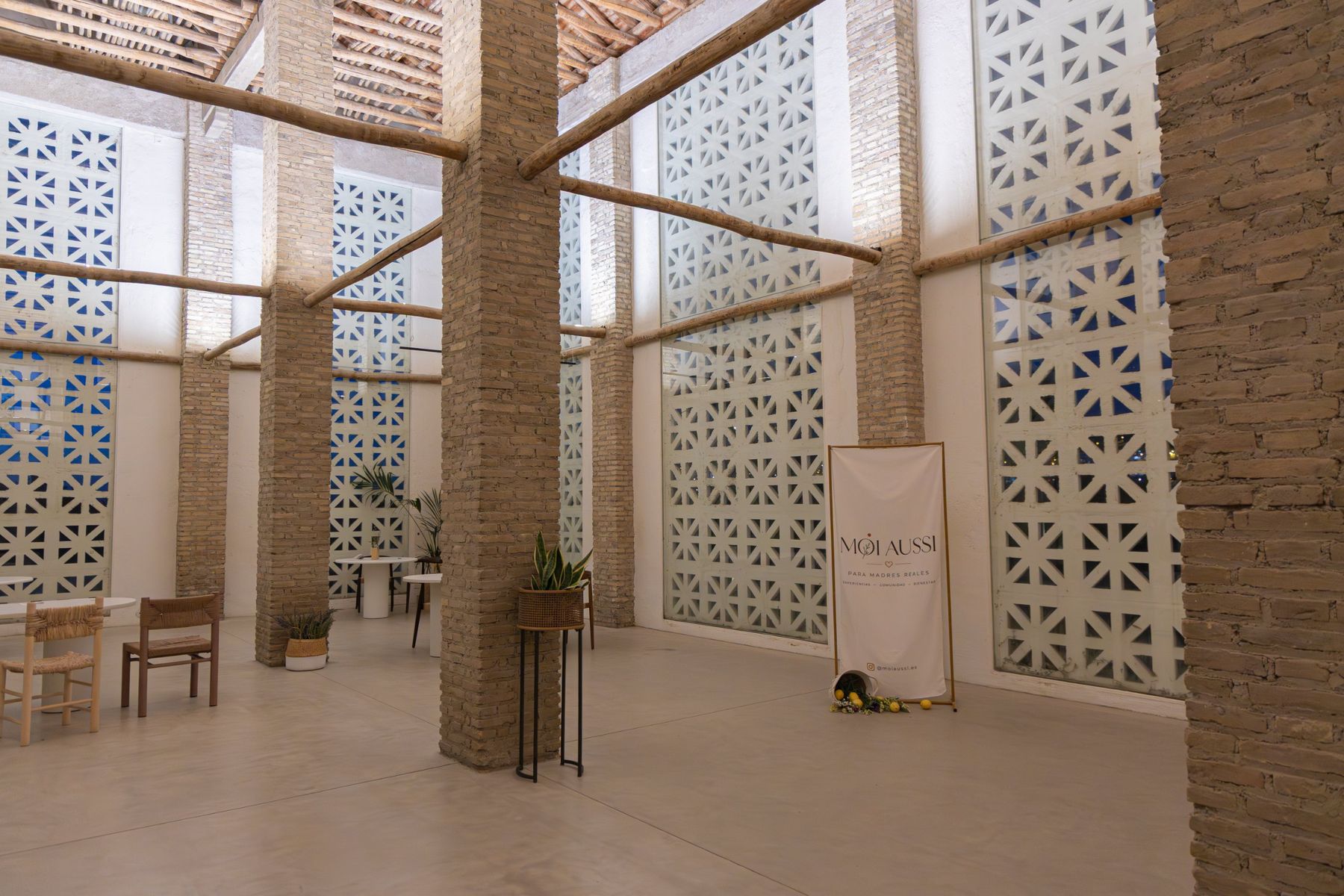 Sala del Cortijo de la Seda con celosías y el cartel de MOI AUSSI